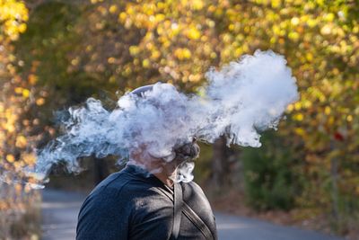 A man smoking a cigarette in autumn
